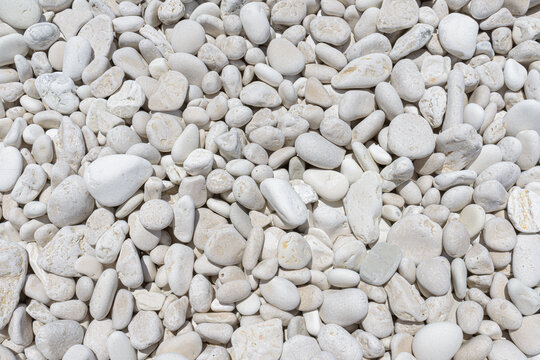 White pebbles forming natural seamless full frame texture.
