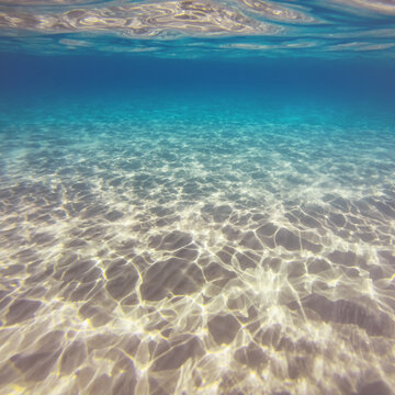 Underwater light reflections creating pattern on sand seabed