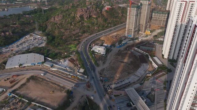 Aparna Zenon Tower buildings with ORR service road, vehicles and Zenon Junction at Makthakousarali, Khajaguda, hyderabad, telangana, india. day time, crane shot, drone shot, 4k.