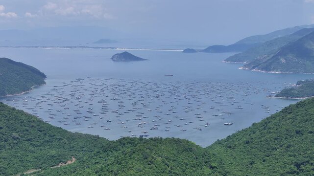 Drone footage capturing a tele 3x zoom view of Vung Ro Bay in Dak Lak (formerly Phu Yen) Province, Vietnam. Filmed from a distant aerial perspective, the footage showcases the bay surrounded by lush