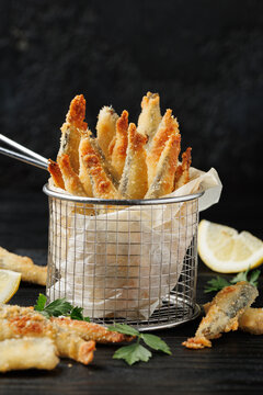 Golden Crispy Fried Sardines Served with Lemon Wedges