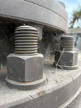 Tornillos de gran tama&ntilde;o anclados a una superficie de metal en estado de abandono