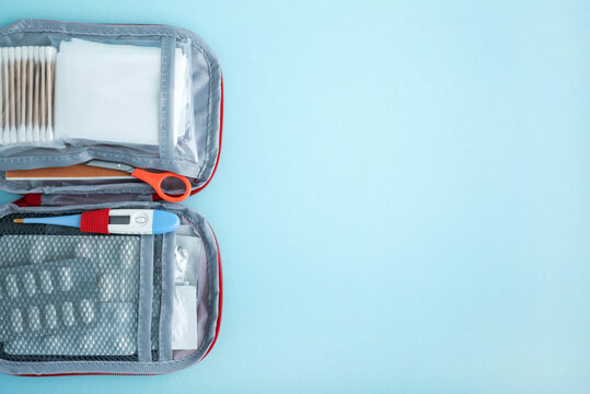 First aid kit open with medical supplies on blue background