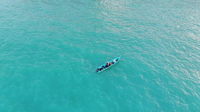 Aerial Drone View of Traditional Fisherman Boat Carrying Tourists Across Crystal Turquoise Ocean Creating an Authentic Tropical Island Adventure