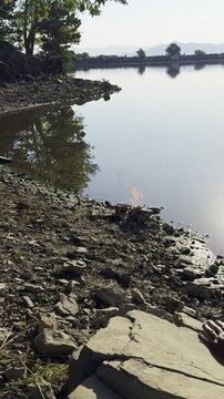 Cinematic Close-Up: Hands Slapping a Rock for Martial Arts Conditioning by a Campfire and Lake