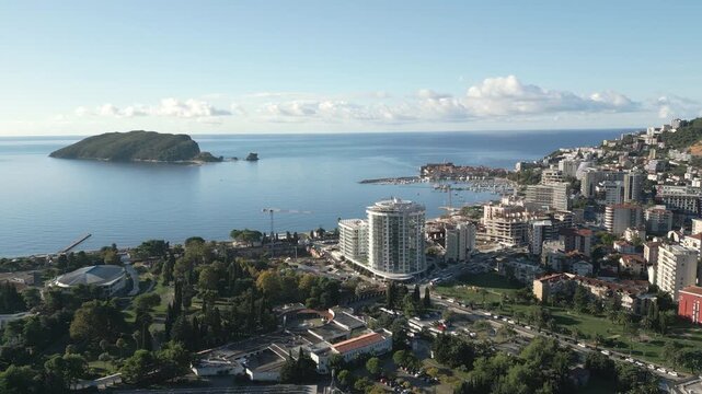 Drone captures a wide panoramic view of Budva, Montenegro under a soft morning sun.