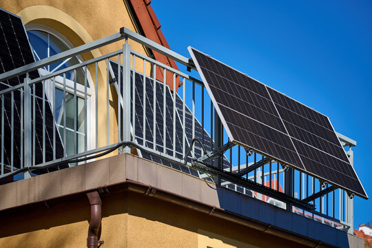 Photovoltaic solar panels mounted on the metal railing of a residential apartment balcony on a sunny day, Gdansk, Pomeranian Voivodeship, Poland, Europe.