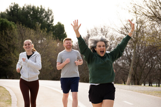 Diverse group of people enjoying a run in the park, celebrating a healthy lifestyle