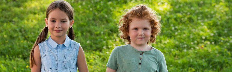 Fototapeta premium Two adorable children enjoy their childhood adventure in a green summer park 