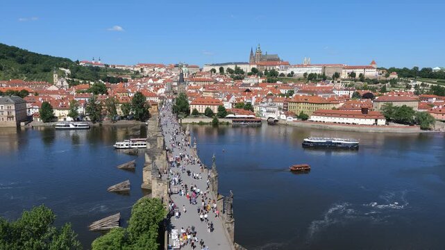 Picturesque city of Prague in Czechia (Czech Republic). Cityscape with view above the Charles Bridge, Prague Castle on a hill and cruise boats on Vltava River.