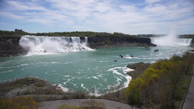 View of people on zip wires with the American Falls and Horseshoe Falls in background from Canada on a sunny day, Niagara Falls, Ontario, Canada, North America