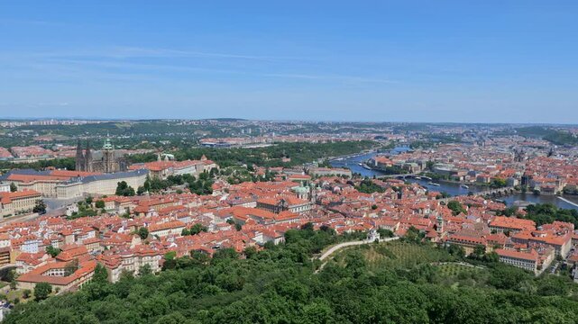 View above city of Prague in Czechia (Czech Republic). Panning to the right cityscape with Castle District (Hradcany), Lesser Town (Mala Strana), the Old Town and Vltava River.