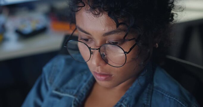 Close-up young Black female programmer coding AI software on multiple screens in night office. Network security, cybersecurity, machine learning, working late, overtime, robotics automation concept.