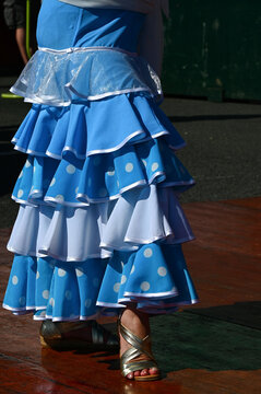 Une femme avec une jupe bleu et blanche &agrave; volants danse le flamenco