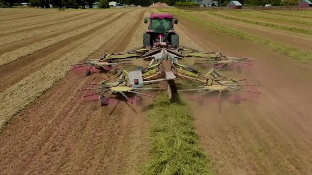 Heavy agricultural machinery operating across a productive crop field in the British countryside. Powerful modern farming equipment carrying out essential field work, showcasing precision agriculture,