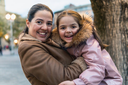 Mother embracing daughter outdoors sharing happy moment
