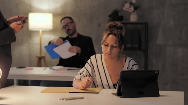 Angry manager scolding a female employee at her desk in the office