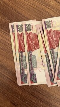 Egyptian banknotes on a wooden table, scattered paper currency, colorful bills, financial or travel context.