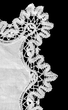 Crochet lace patterns, crocheted Grandmas Doily, Detail of hand-crocheted tablecloth isolated on black background border art design. Craft, vintage linen. Hobby concept. flat lay. Vertical image 