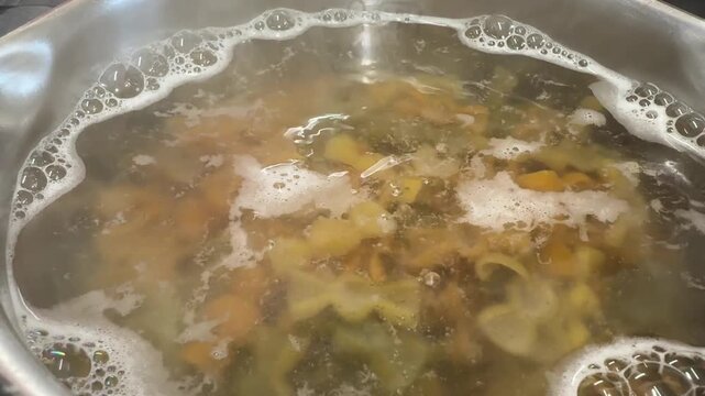 Pasta boils in a large pot of salted bubbling water, steam rises in gentle clouds, golden noodles swirl and soften to perfect al dente texture, a warm and simple dinner moment, candid authentic life.