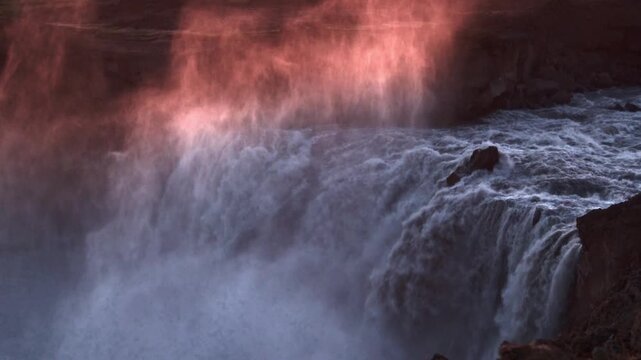 Close-up of Aldeyjarfoss waterfall crashing through basalt gorge with rosy backlight, Iceland