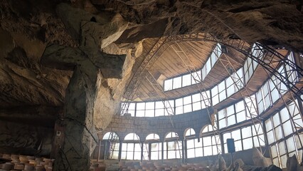 Big rocky cross in front of the dome window in a cave in Cairo, Egypt © Noriko
