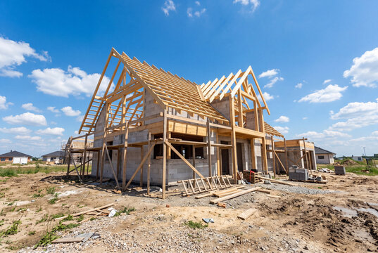 Single-family house under construction (shell stage). Low-angle view of the construction site.