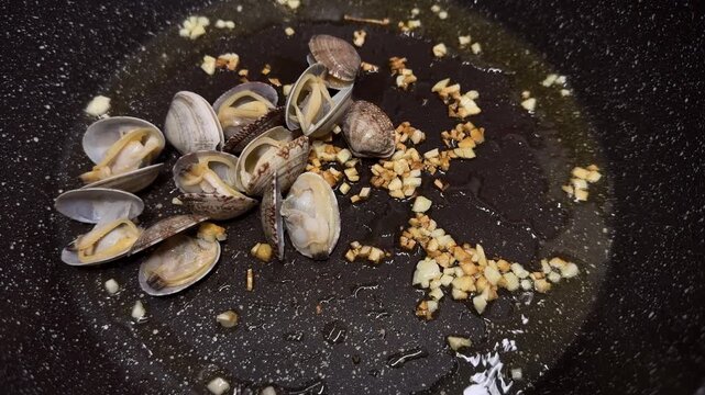 Vongole clams in a hot skillet, garlic butter sauce, sizzling seafood, Italian dish, aromatic.