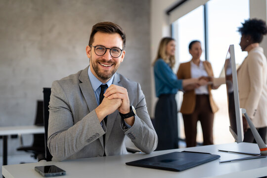 Confident businessman in modern office wearing suit and tie, showcasing executive leadership