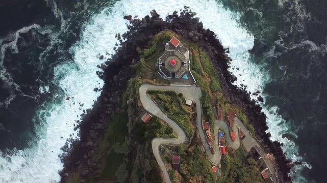 Wide aerial over switchback road descending to lighthouse cape and surf scene setter, S&Atilde;&pound;o Miguel, Azores