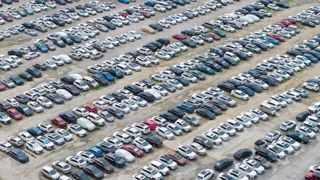 Top-down aerial view of neat landscaped outdoor parking lot full of cars	