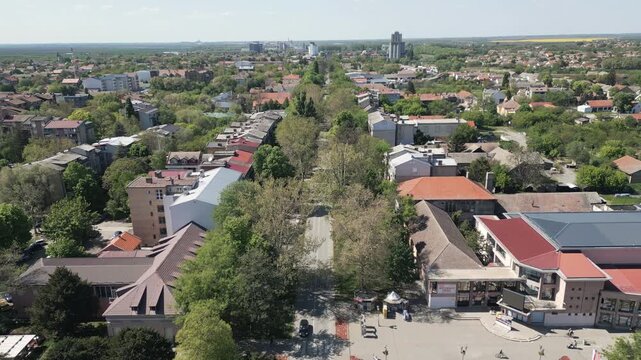 Main street tree lined avenue and flatland panorama of Vrbas, northern Serbia in a forward moving drone shot on a sunny day.