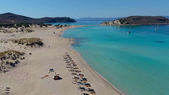 Relax on the golden sands of Simos Beach in Elafonisos, Greece. Clear turquoise waters invite you to unwind while stunning landscapes enhance your holiday experience in this serene paradise.