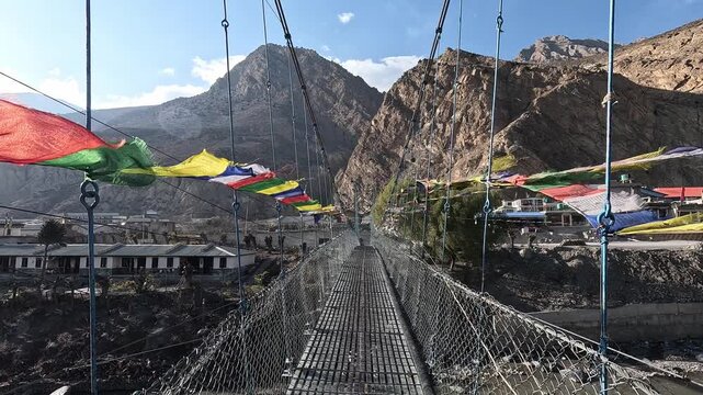 Suspension footbridge prayer flags canyon village Jomsom Mustang Nepal Himalaya Kali Gandaki