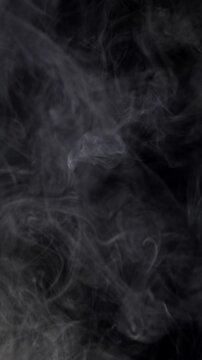 Gray Smoke on Black Background. Wispy vapor drifts and curls slowly, creating a dark atmospheric overlay.