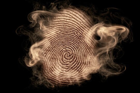 Close-up of a textured fingerprint enveloped in swirling smoke against a dark background, symbolizing identity and mystery.