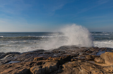 Fototapeta premium Waves crashing against coastal rocks