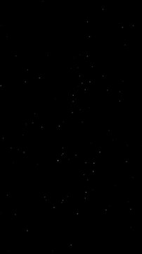 Animation with effects of small shining stars twinkling on black background. 4K Vertical.