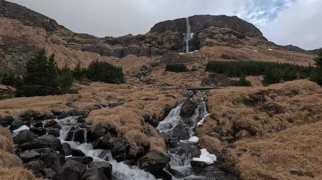 Wide view over glacial river cascading over black basalt rocks below Bjarnafoss waterfall, Snaefellsnes Peninsula, Iceland