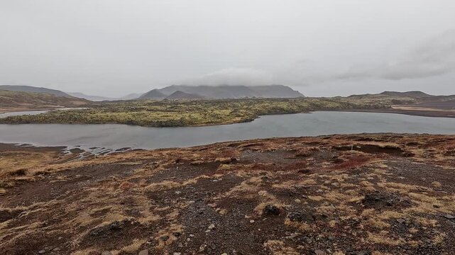 Selvallavatn lake with moss-covered lava plain and volcanic cinder cone, overcast, Snaefellsnes, Iceland