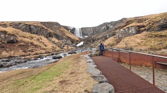 Tourist at viewing platform of Svodufoss waterfall, basalt canyon and river, Snaefellsnes Peninsula, Iceland