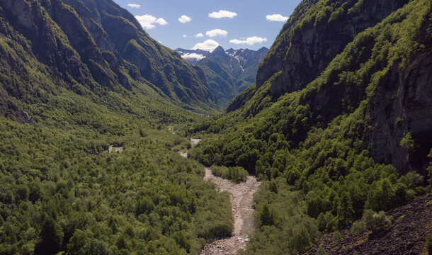 Aerial view of forested Valle Bavona valley stretching toward snow capped peaks