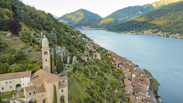 Aerial view of Morcote village on Lake Lugano with church bell tower and mountains

