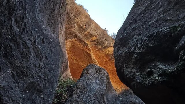 Barranco de Luna low-angle, orange-lit limestone overhang and narrow sky gap above sculpted canyon walls, Granada, Spain