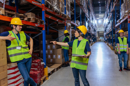 Warehouse colleagues discussing task, pointing, showing conflict