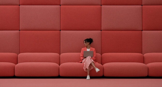 Young girl on a red couch. Child enjoying literature in a cozy living room setting.