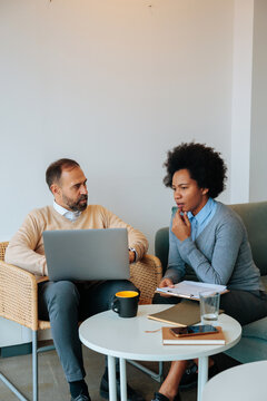 Business people collaborating on project in casual meeting