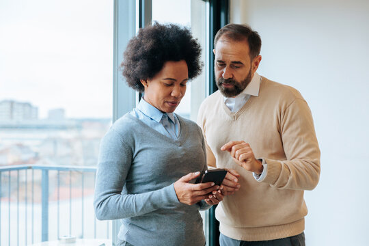 Diverse business colleagues discussing mobile content together