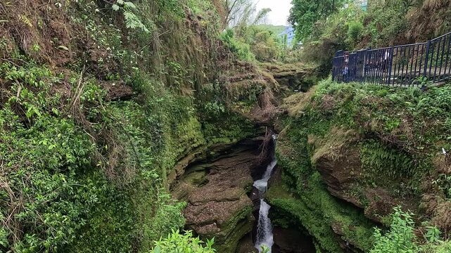 Davis Falls gorge where the Pardi Khola stream plunges into a mossy slot canyon, Pokhara, Nepal