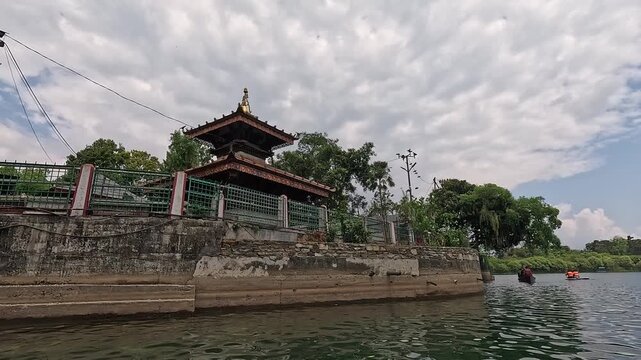Doonga boat POV arriving at the Tal Barahi island temple on Phewa Lake, Pokhara, Nepal